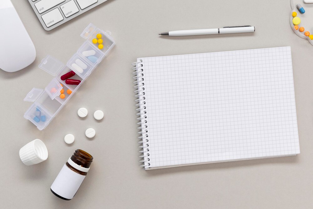 Notebook and pills on table